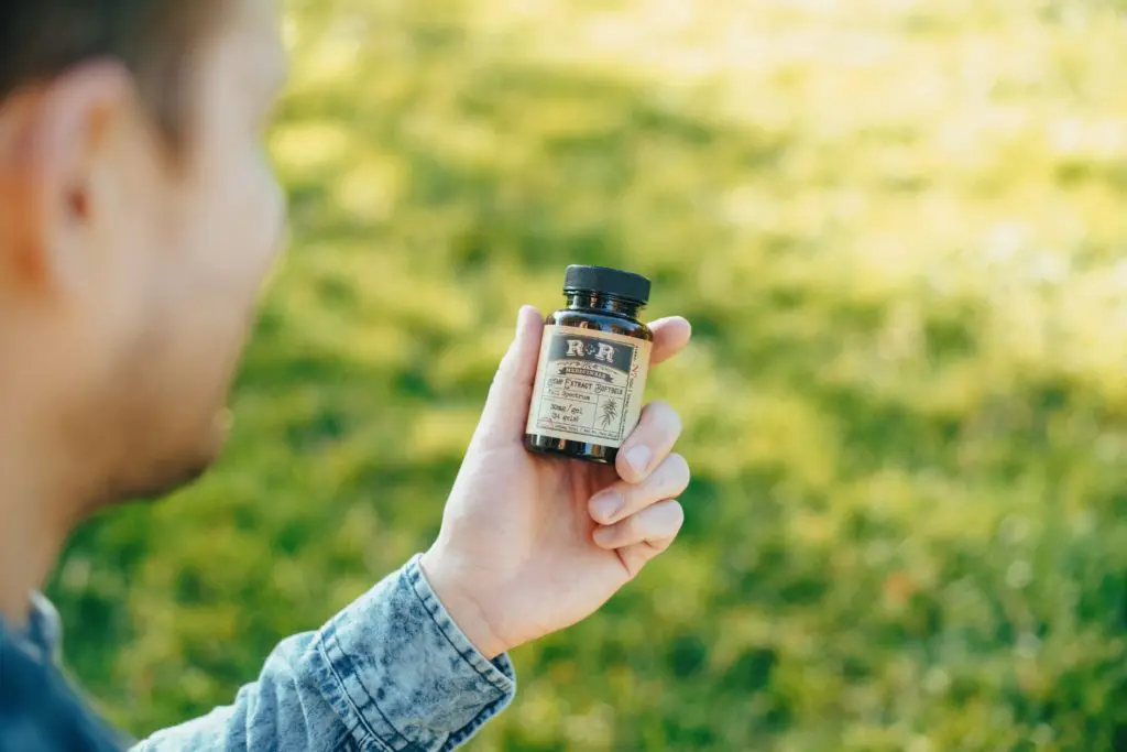 person holding CBD bottle | hearth health happiness