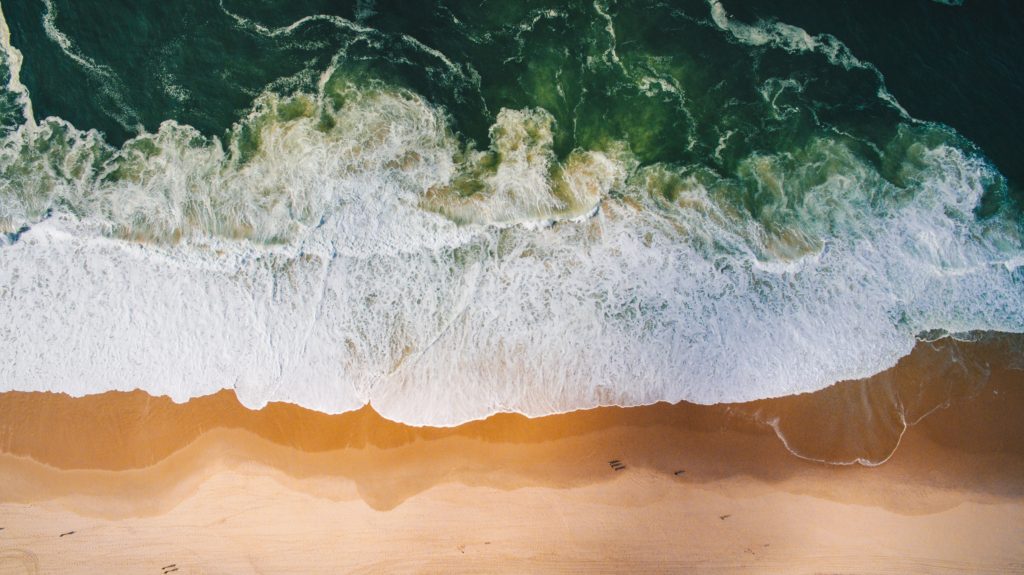 overhead image of ocean waves crashing on beach | hearth health happiness