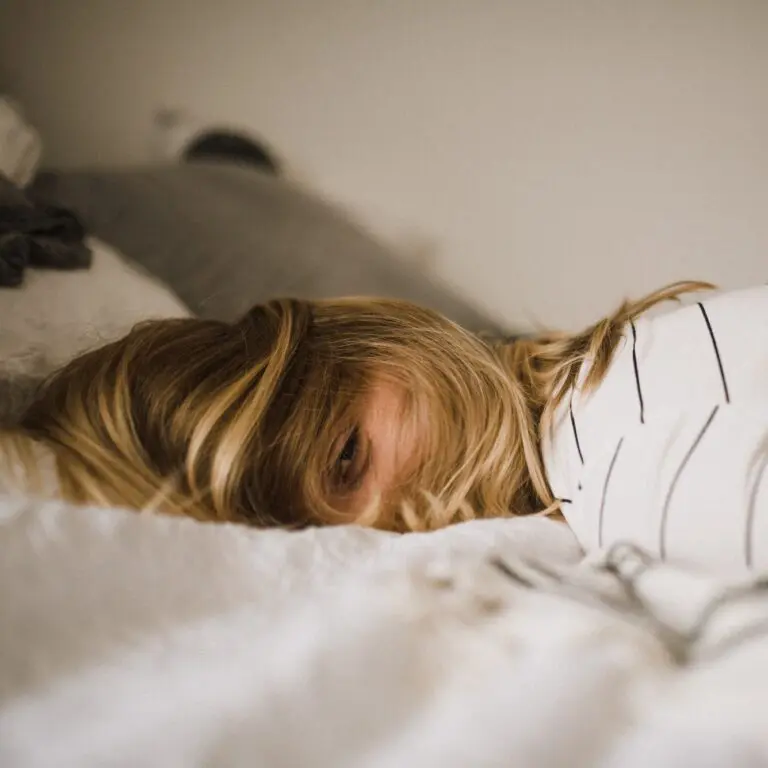 female napping on bed | lifestyle | Photo by Kinga Cichewicz on Unsplash | hearth health happiness