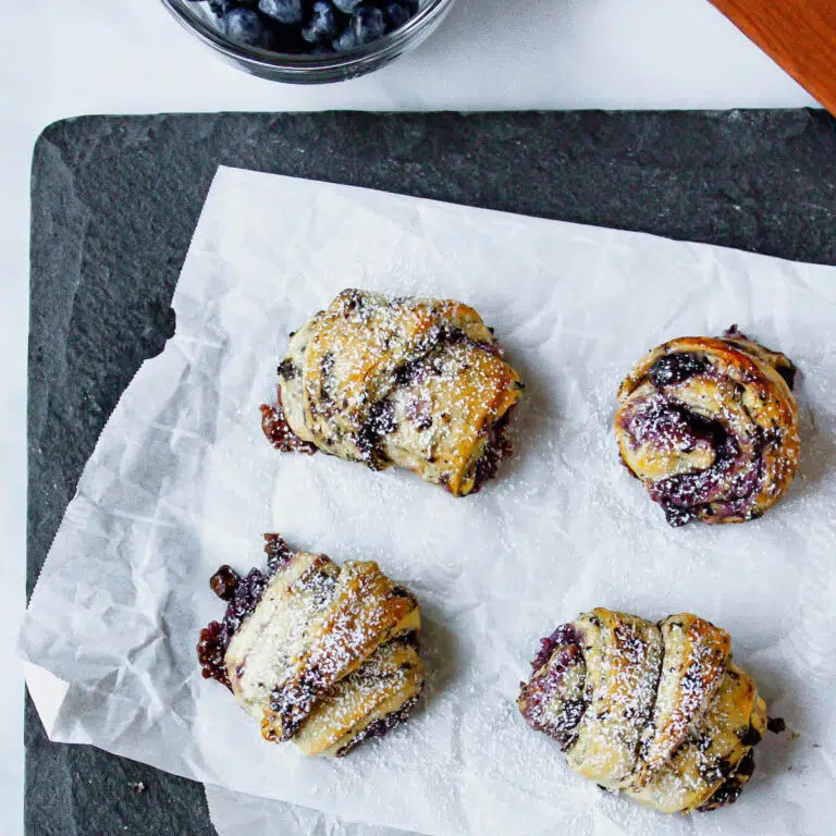 overhead image of blueberry crescent rolls on piece of parchment paper