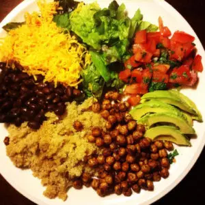 deconstructed taco bowl | chickpeas, quinoa, black beans, shredded cheese, shredded lettuce, pico de gallo, and avocado