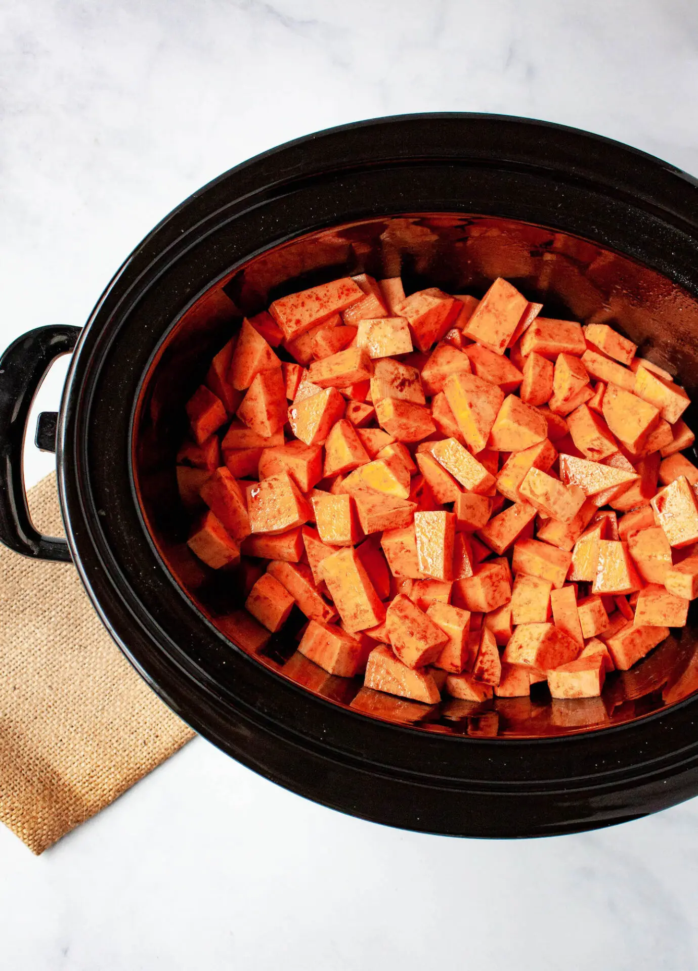 overhead image of sweet potato pieces in slow cooker