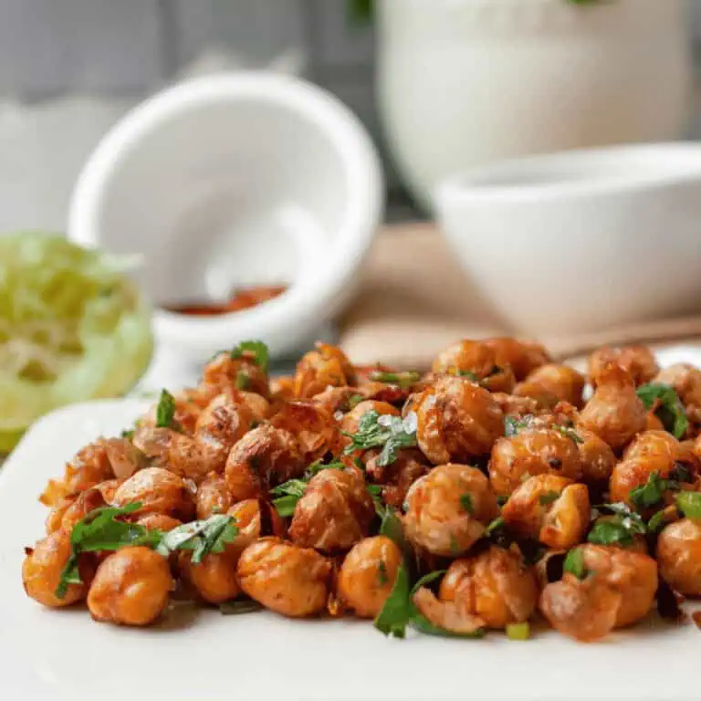 closeup of chili lime roasted chickpeas on serving dish with ingredients blurred in the background