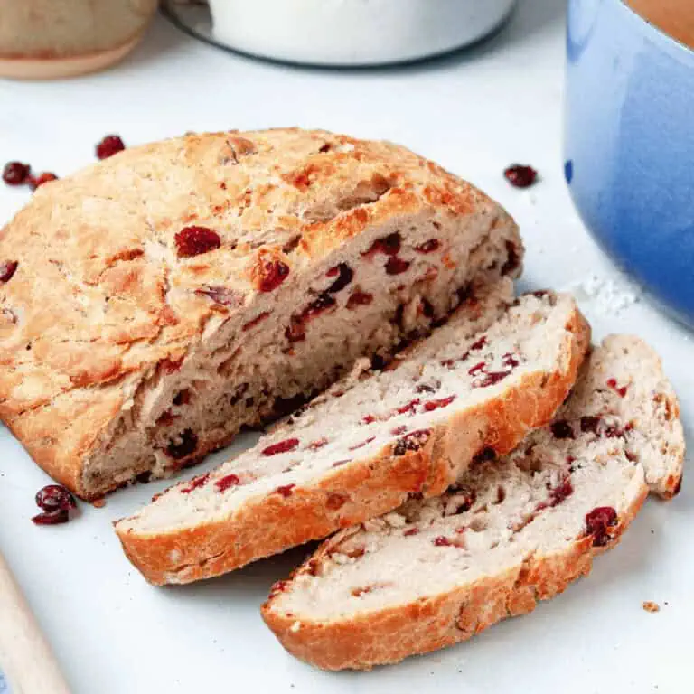 closeup of cranberry boule bread loaf with a few slices falling forward to show interior texture