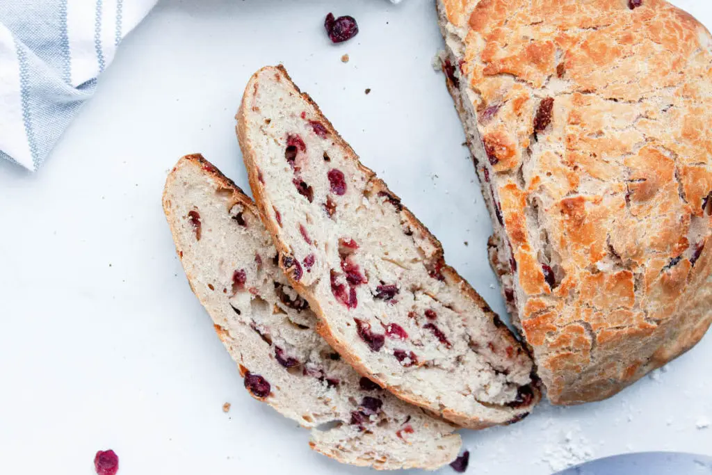 overhead image of cranberry boule bread loaf partially sliced
