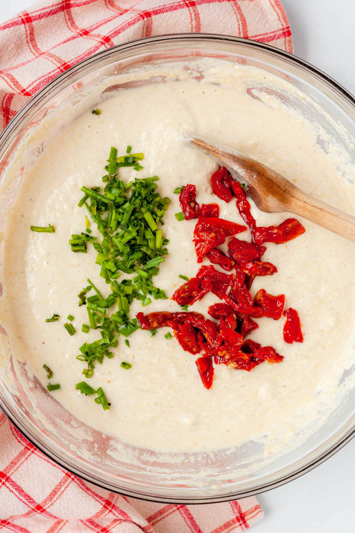 plant-based cornbread dough with tomatoes and chives in bowl