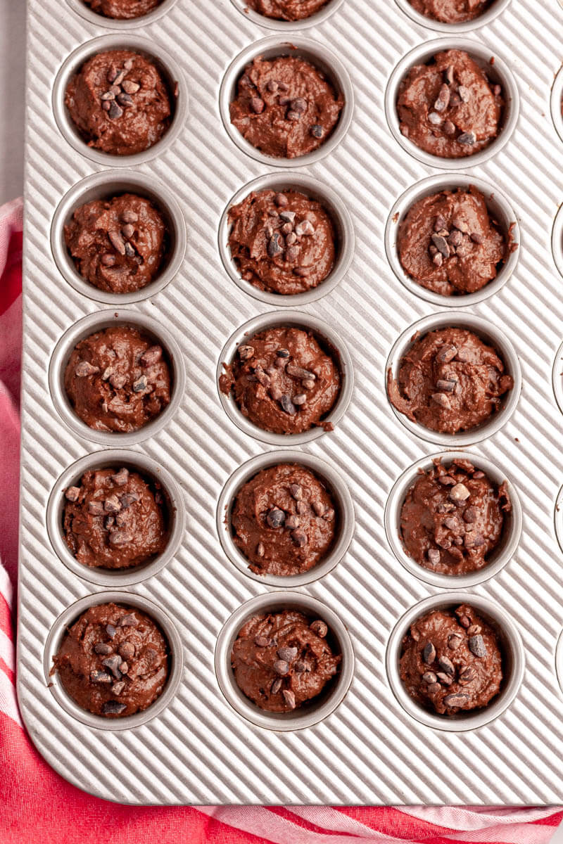 overhead image of brownie bite batter in mini muffin tin before baking