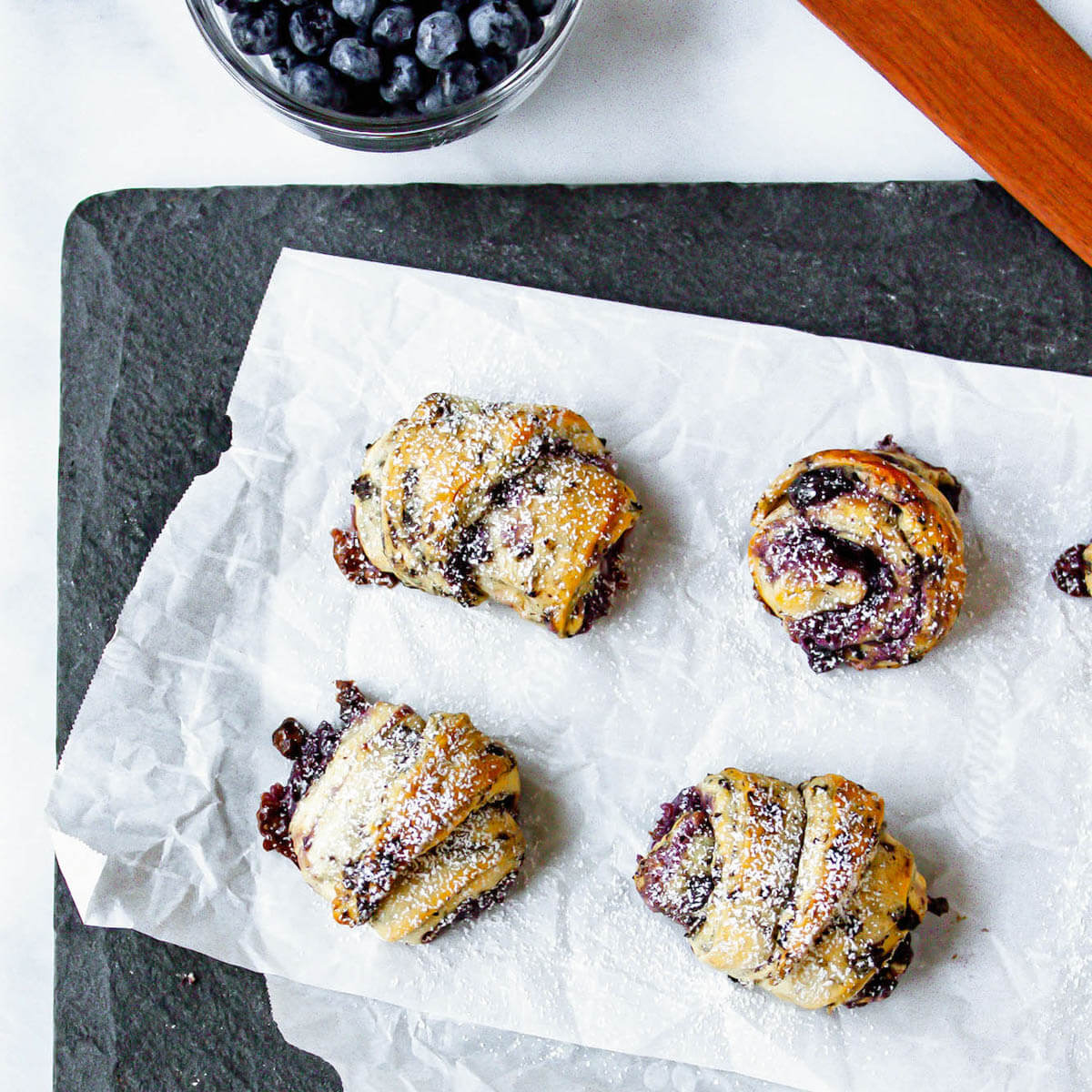 overhead image of blueberry crescent rolls on parchment paper