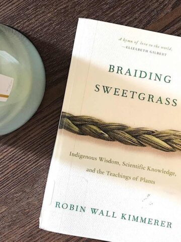 Braiding Sweetgrass book on coffee table with candle