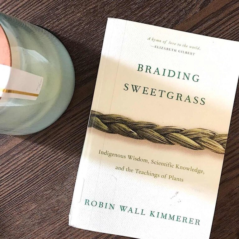 Braiding Sweetgrass book on coffee table with candle