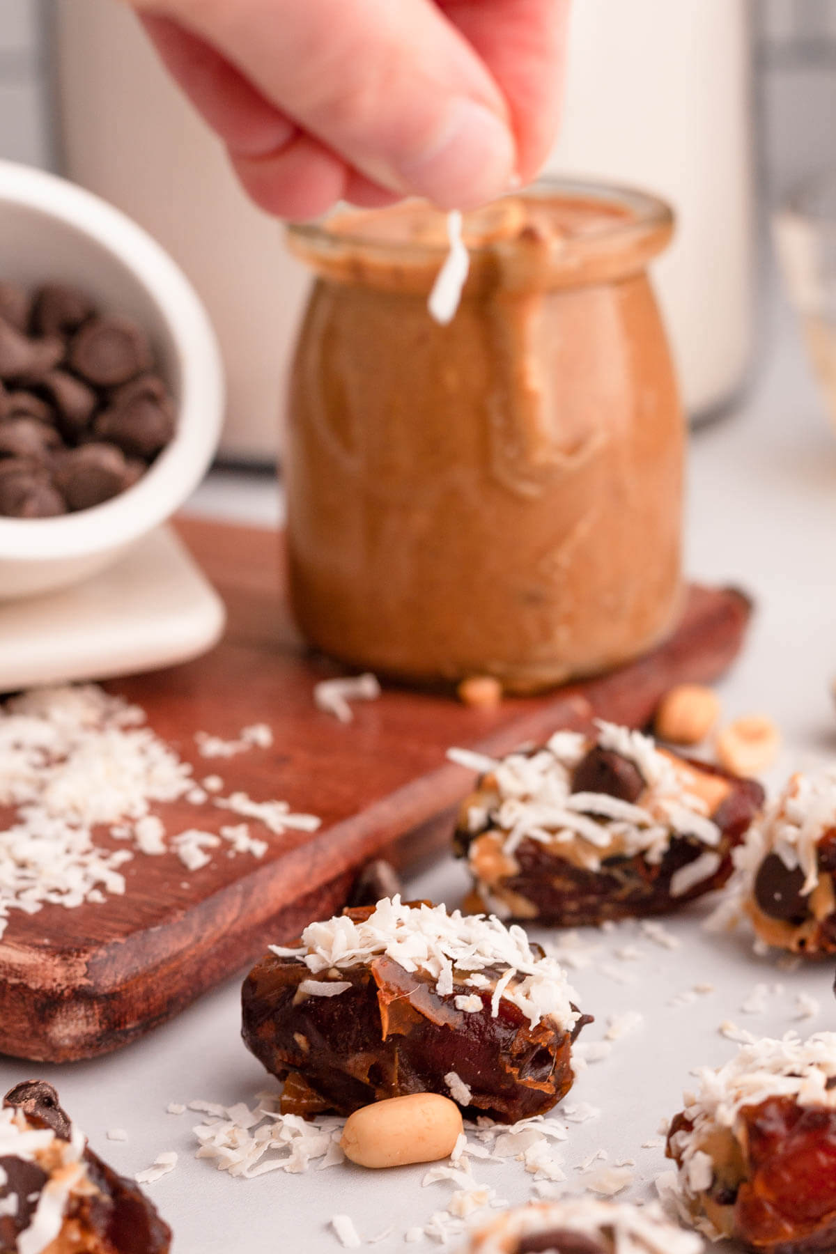 sprinkling shredded coconut over peanut butter dates