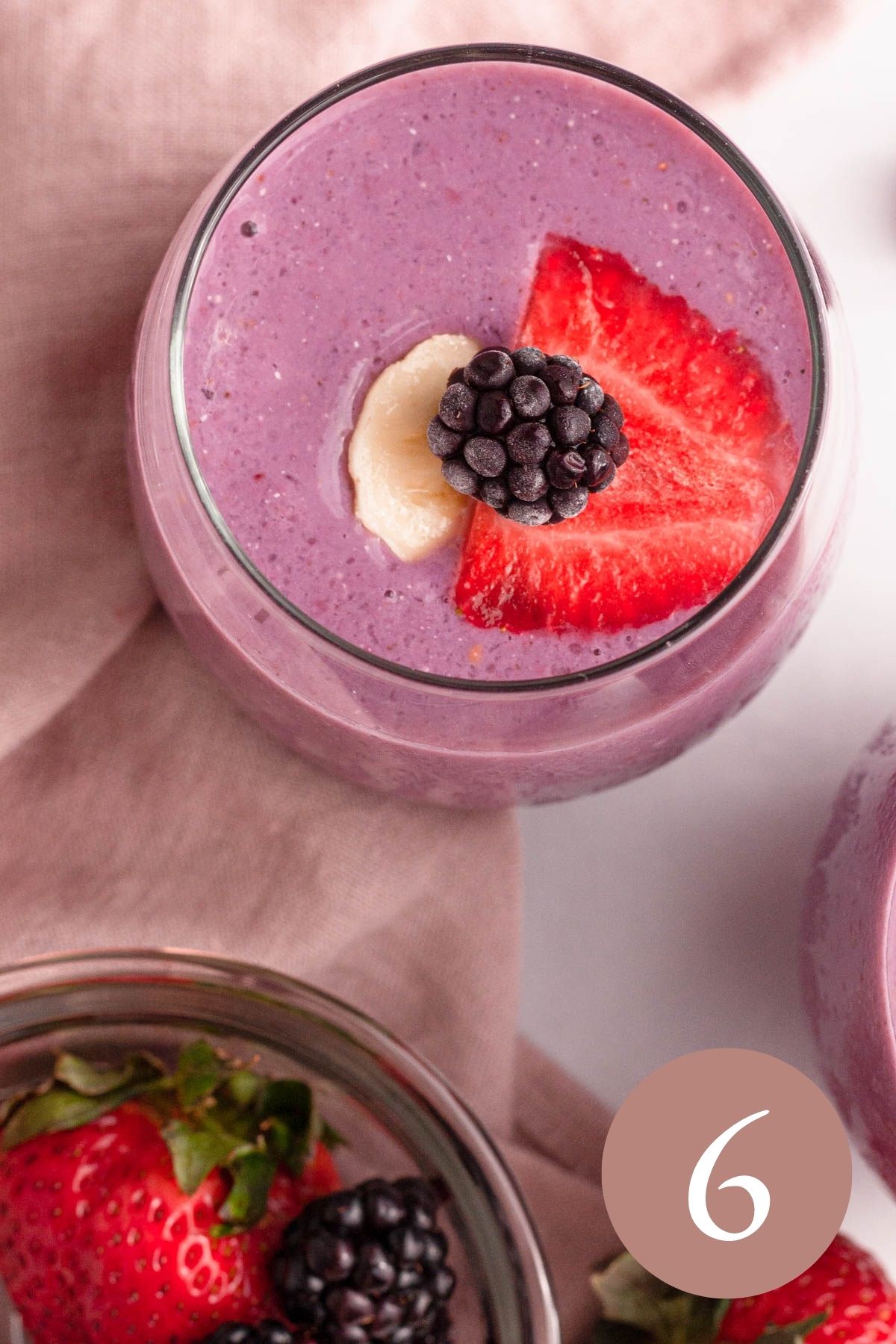 overhead image of blackberry strawberry banana smoothie topped with fresh fruit