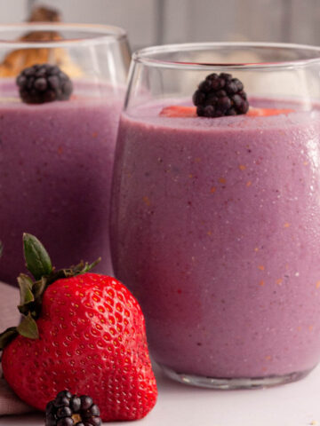 side image of blackberry strawberry banana smoothie glasses on counter