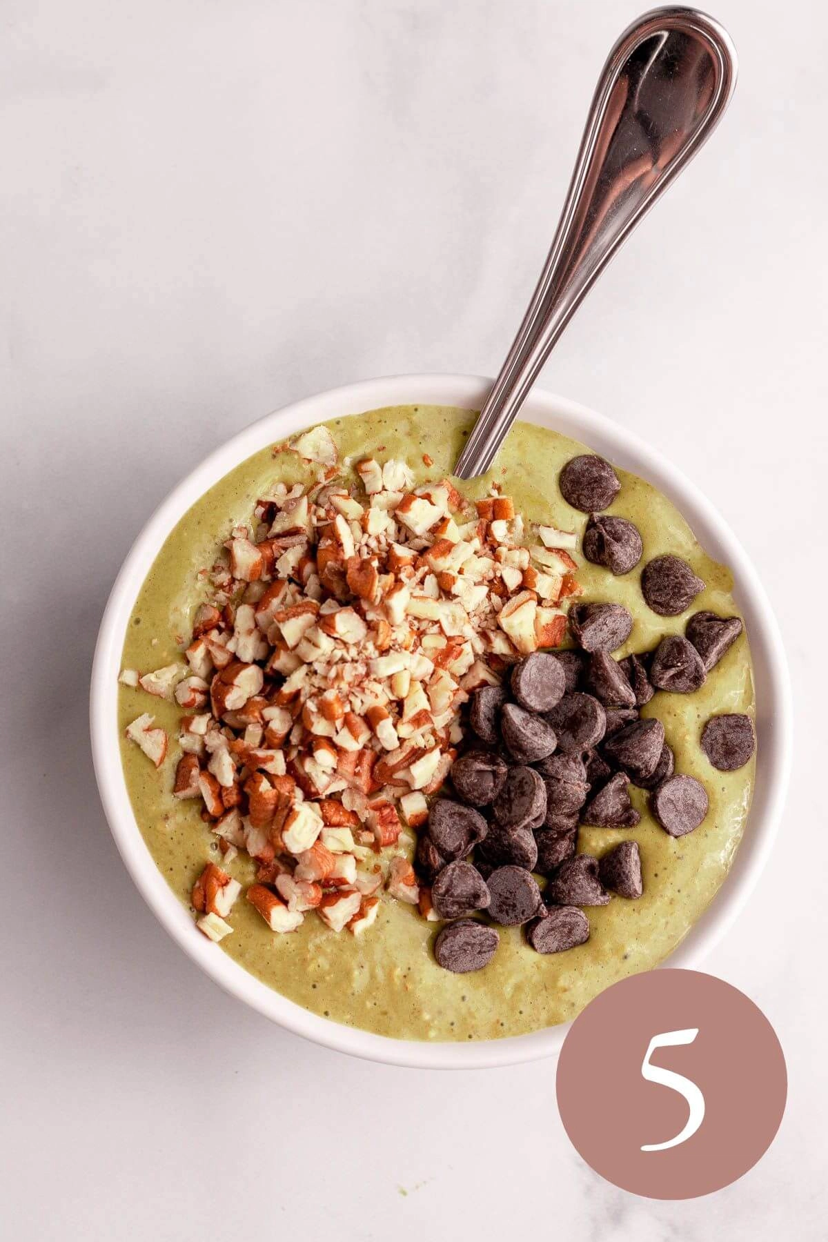 overhead image of matcha baked oats before baking with pecans and chocolate chips