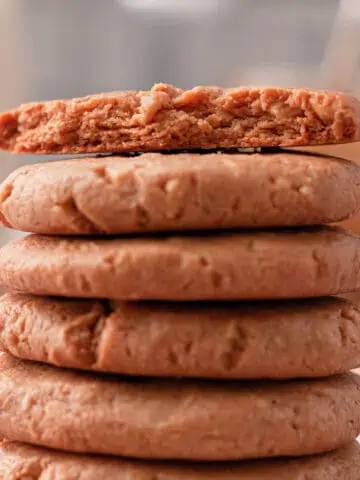 side image of stacked peanut butter cookies with bite taken from cookie on top