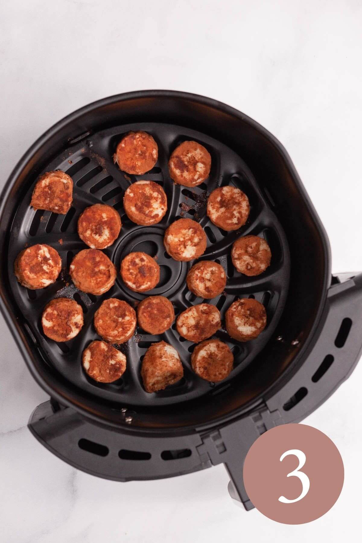 overhead image of cinnamon coated air fryer bananas added to air fryer basket