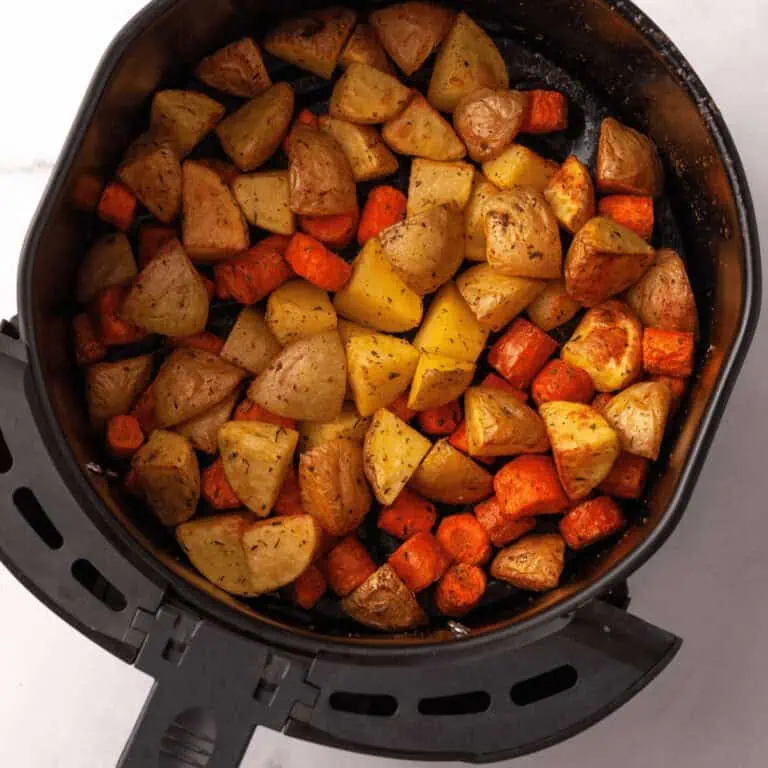 overhead image of carrots and potatoes in air fryer basket