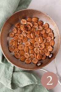 Overhead image of organic pecan halves in skillet