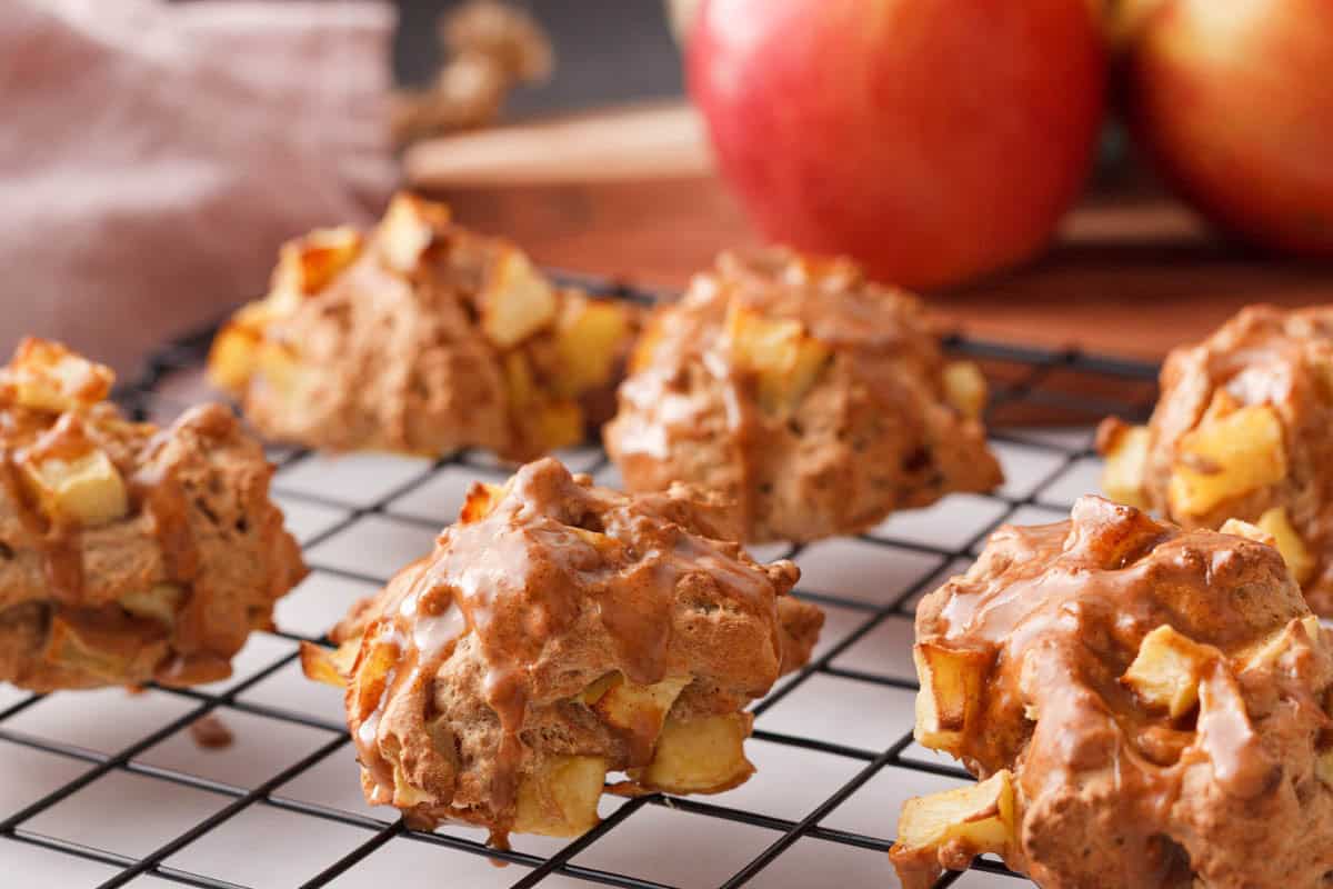 closeup of applesauce fritters cooling on rack after glaze has been applied