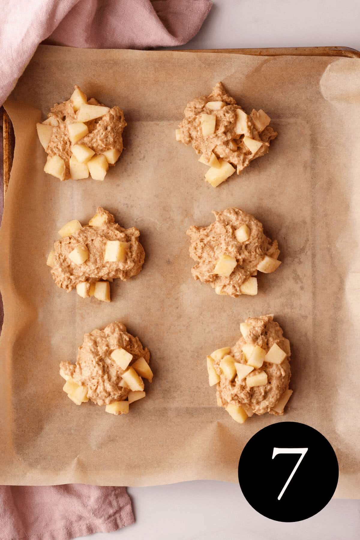 overhead image of applesauce fritter dough on parchment lined baking sheet