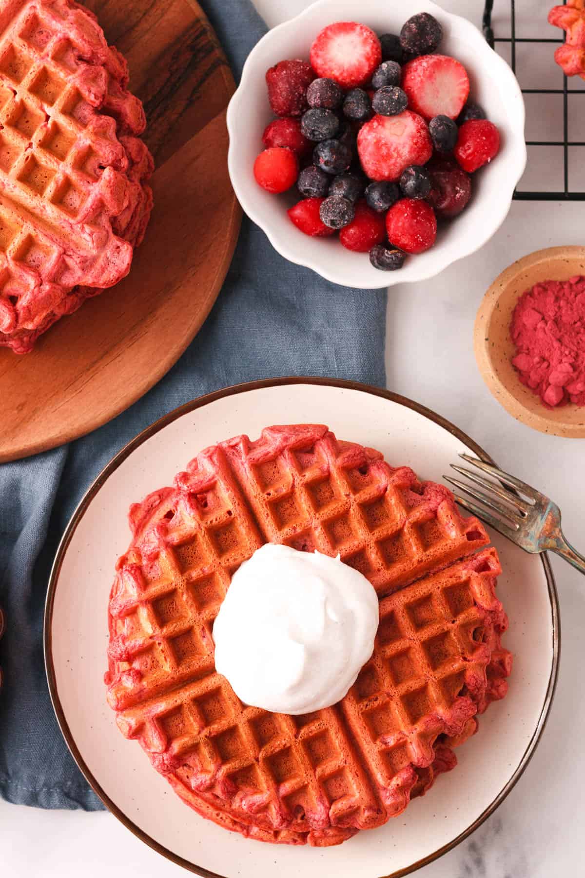 overhead image of waffles on counter with toppings to the side 