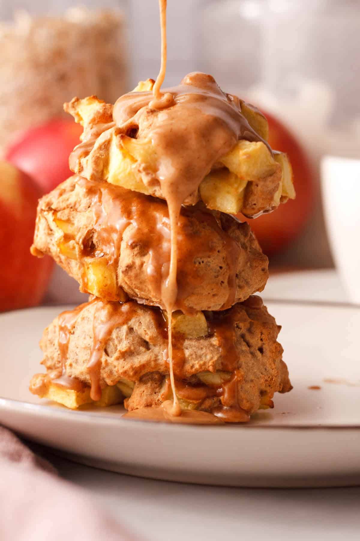 side image of 3 stacked applesauce fritters with vanilla cinnamon glaze over the top