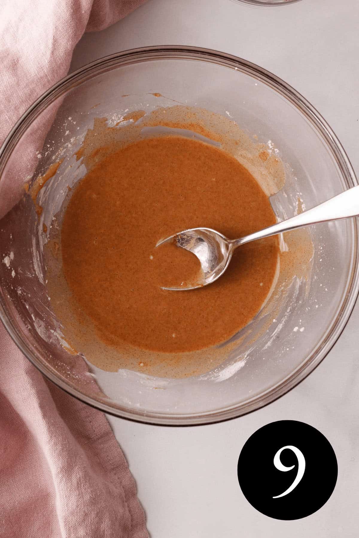 overhead image of vanilla cinnamon glaze in bowl with mixing spoon