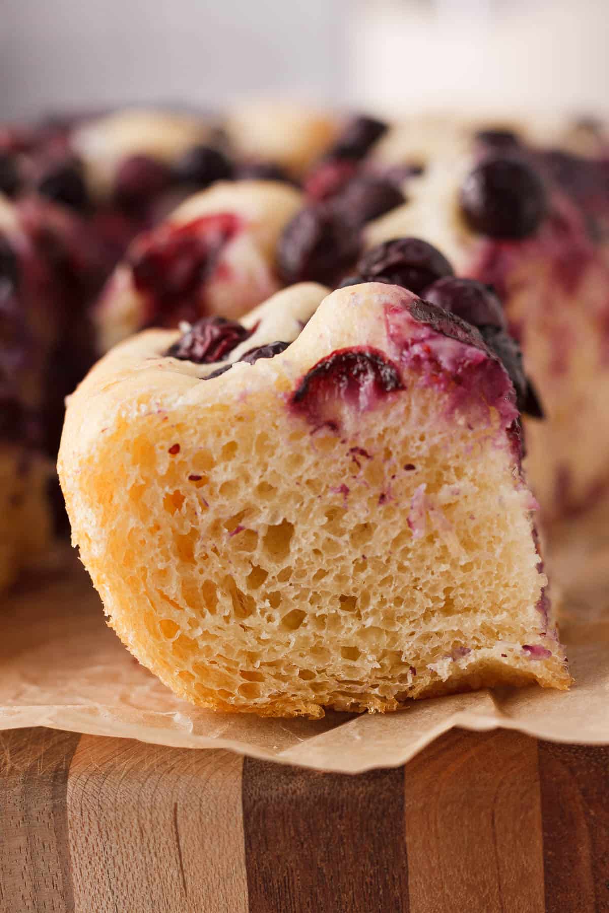 side angle image of blueberry focaccia slice to show interior texture