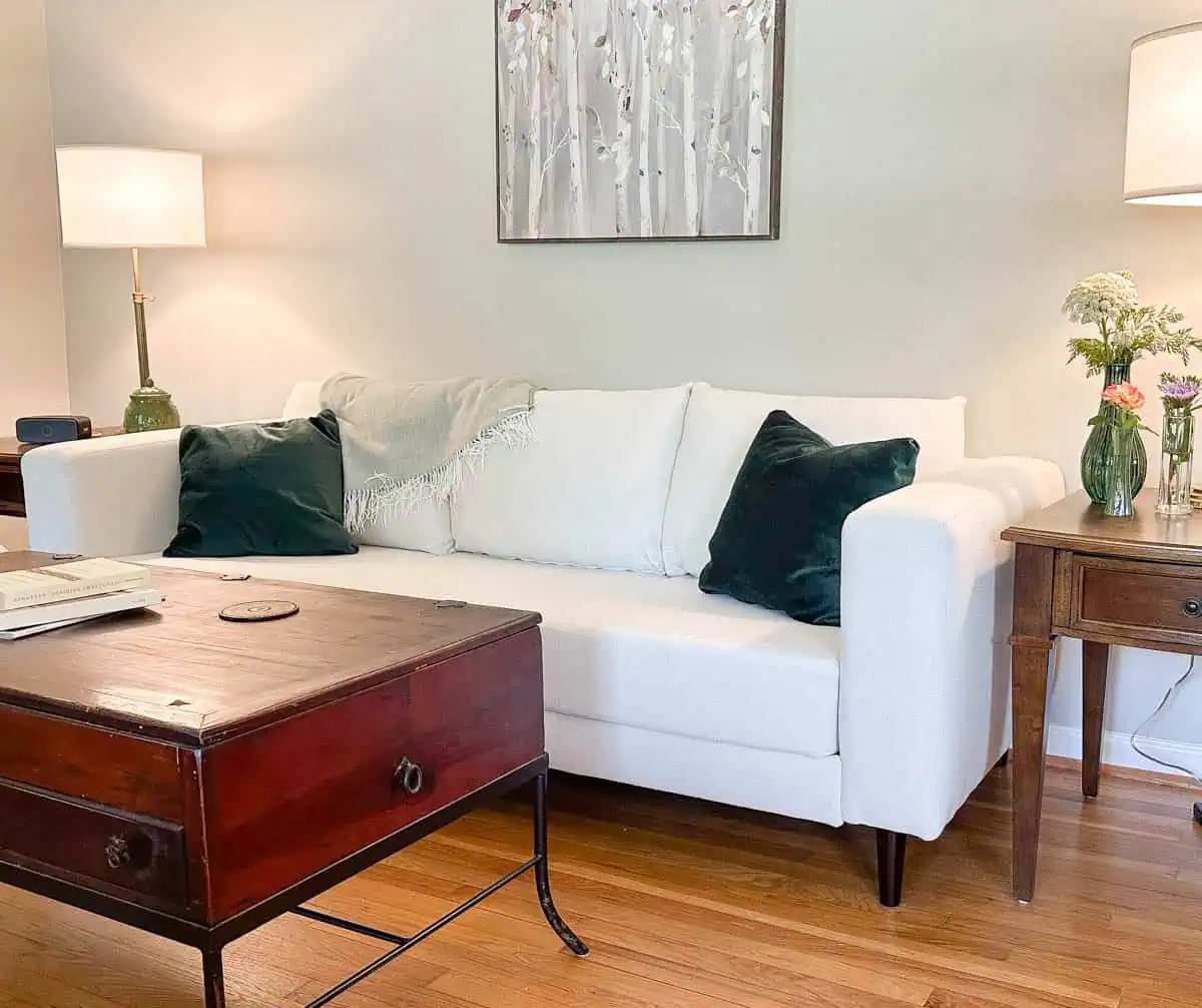 angled image of white couch in living room with coffee table in foreground