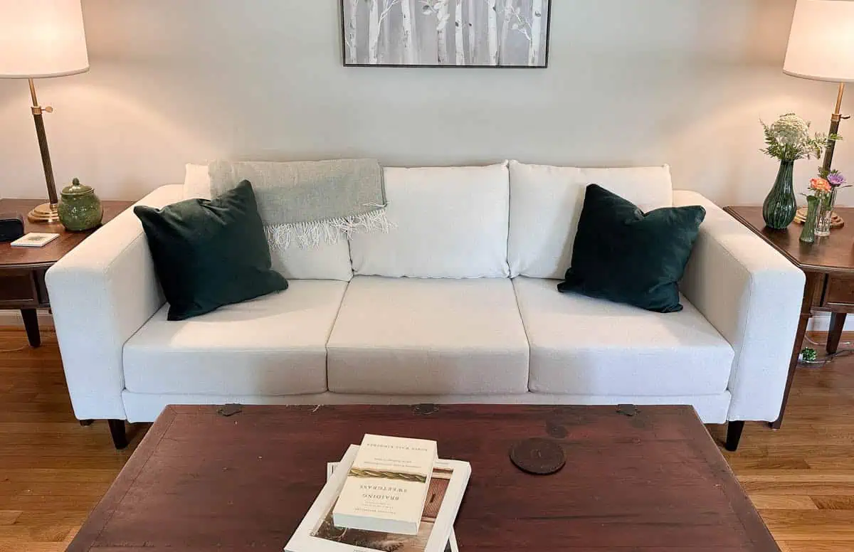 head on image of white sofa with emerald green pillows in living room