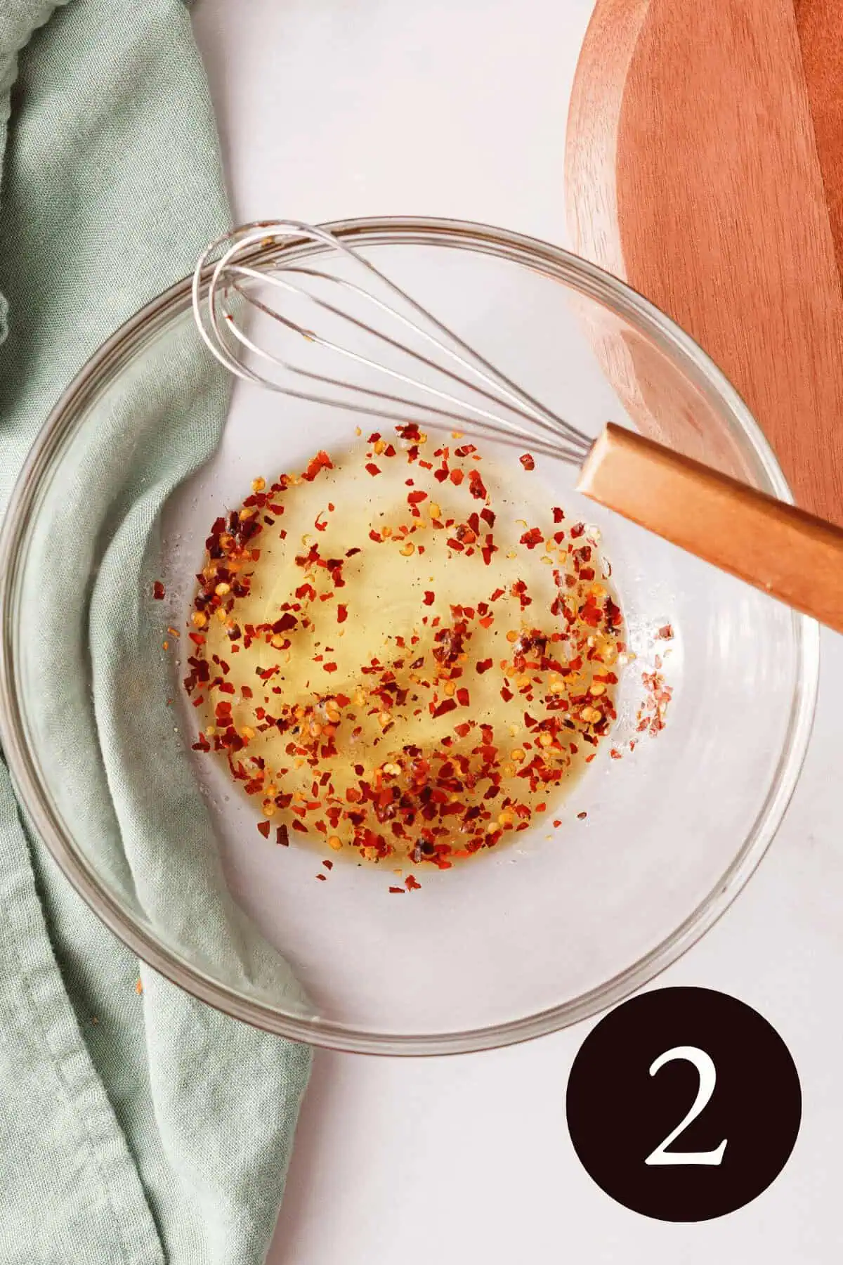 overhead image of whisked carrot seasoning in glass bowl