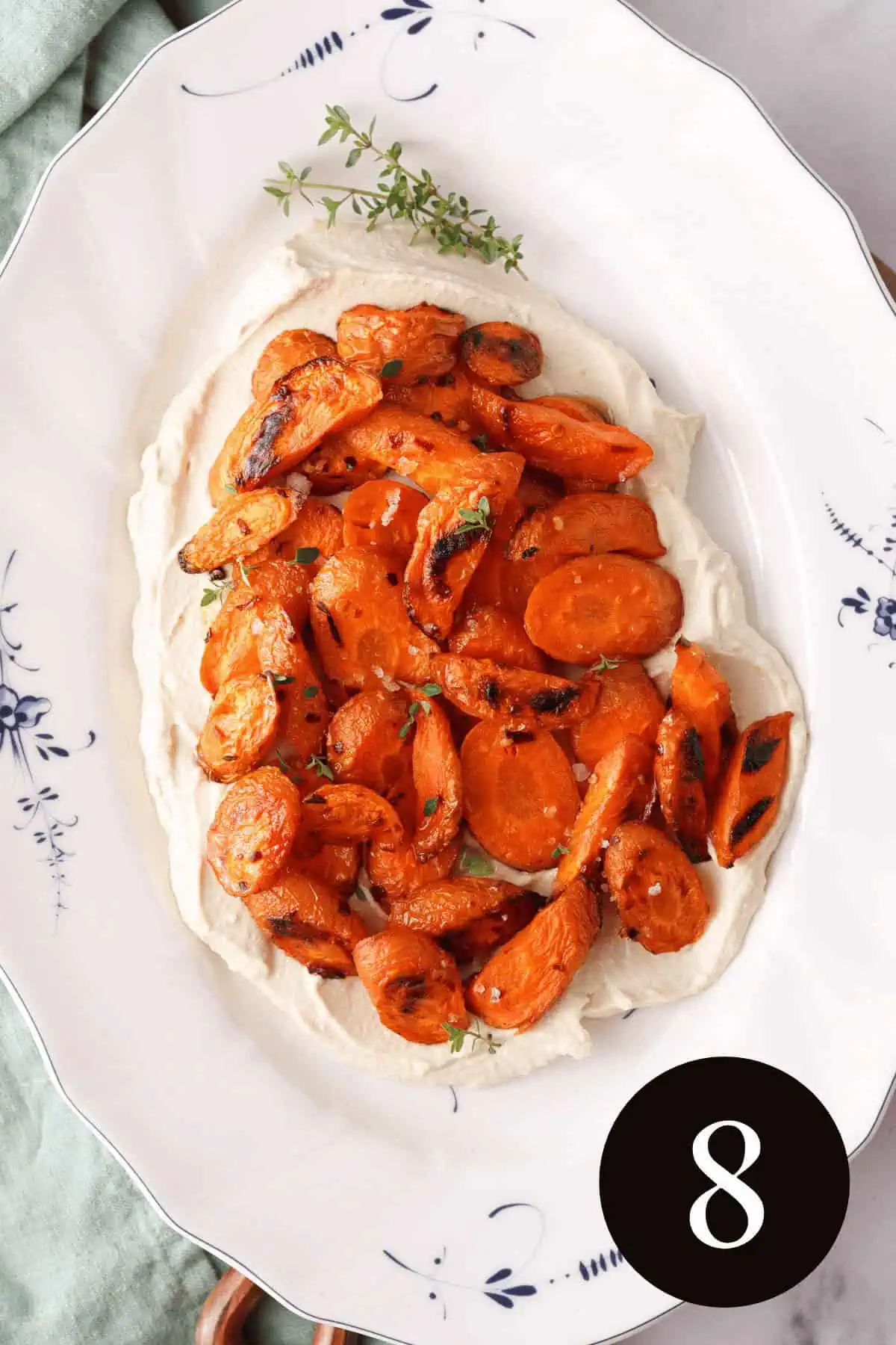 overhead image of roasted carrots on layer of vegan whipped feta