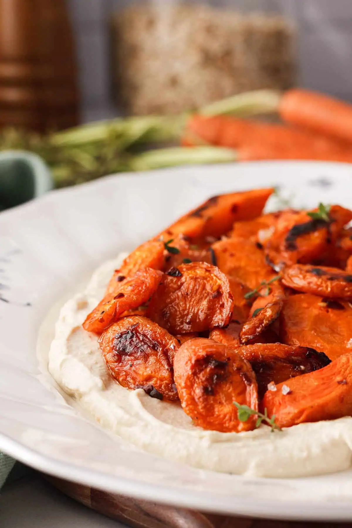 angled closeup of roasted carrots sitting on bed of vegan whipped feta