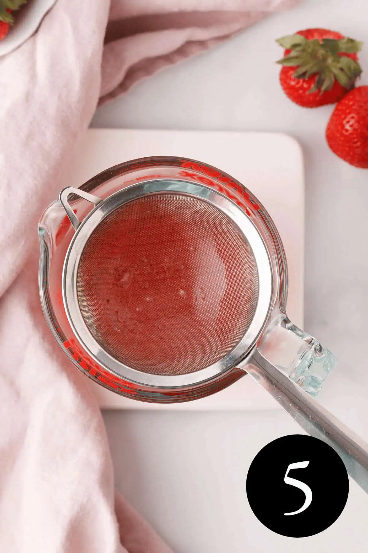 overhead image of smaller mesh strainer over a measuring cup