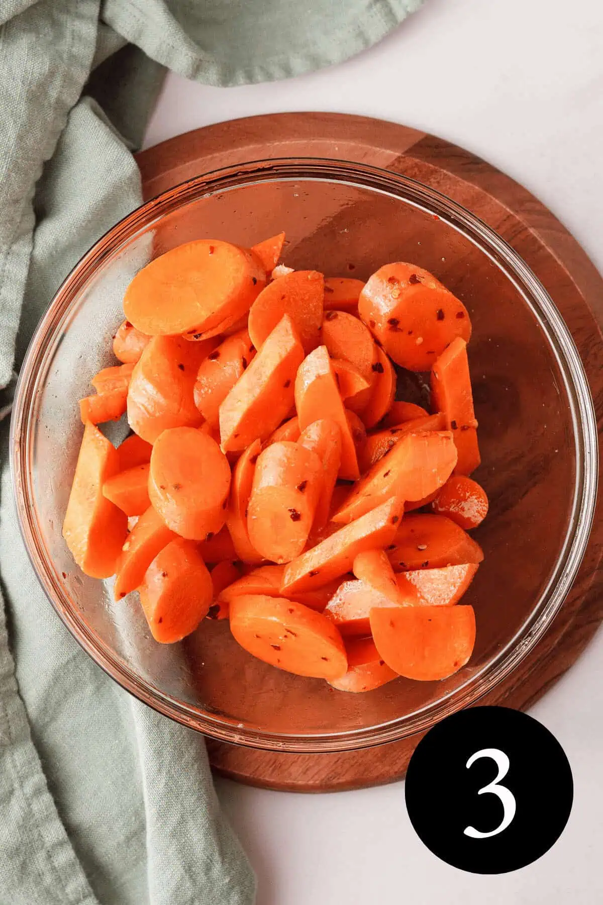 overhead image of coated carrots in glass bowl