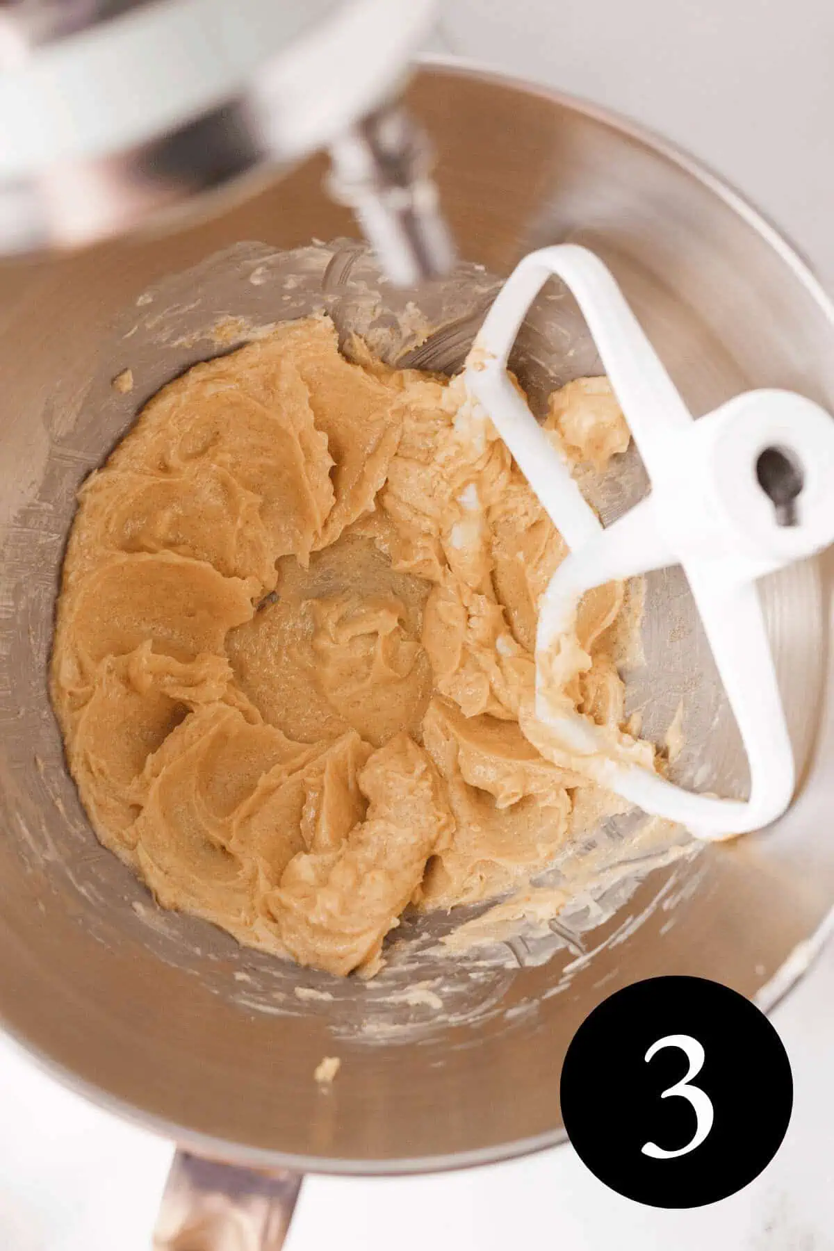 overhead image of creamed butter, sugar, and vanilla extract in bowl of stand mixer