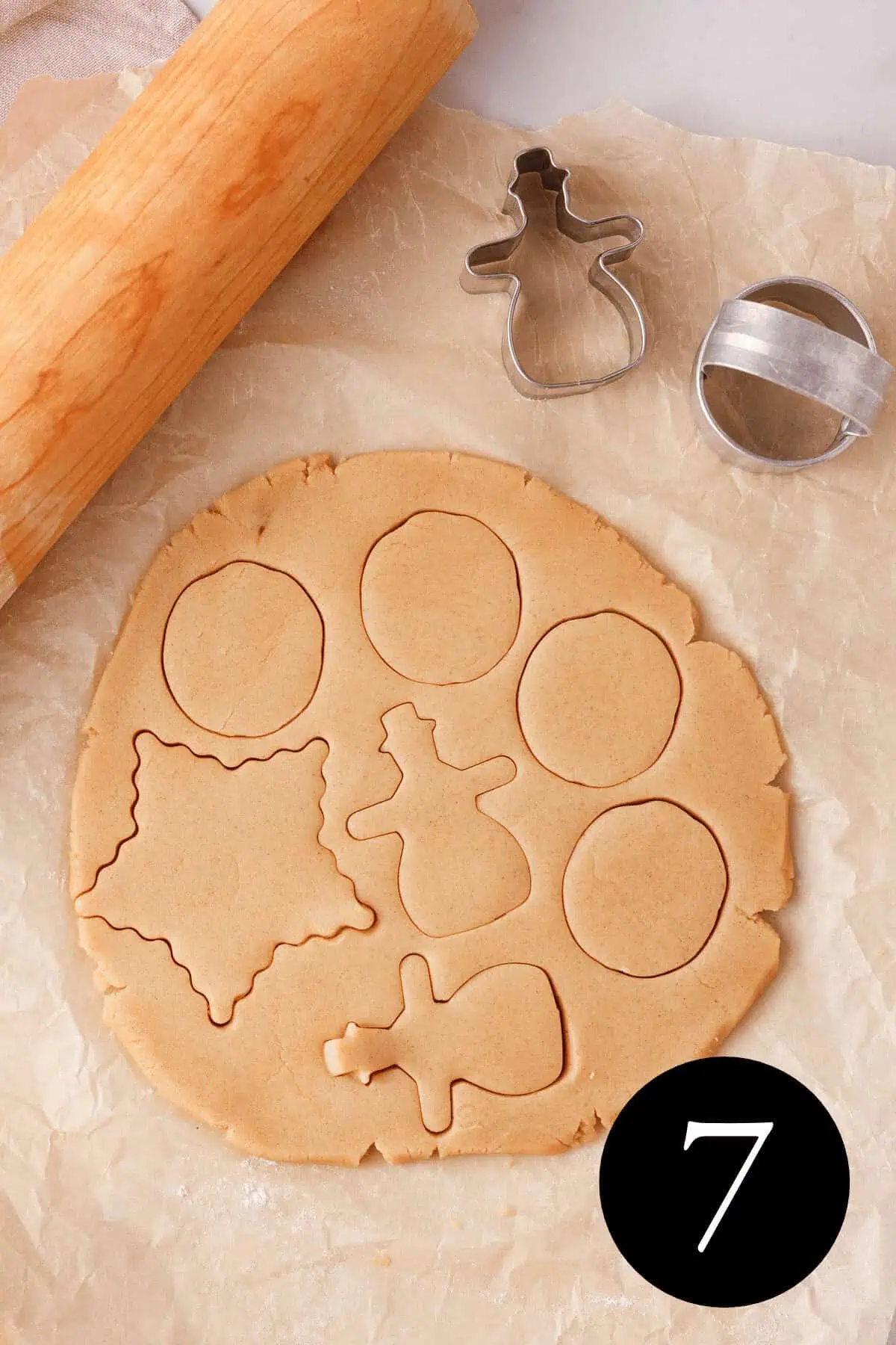 overhead image of cinnamon shortbread dough rolled out with cookie cutter imprints in the dough