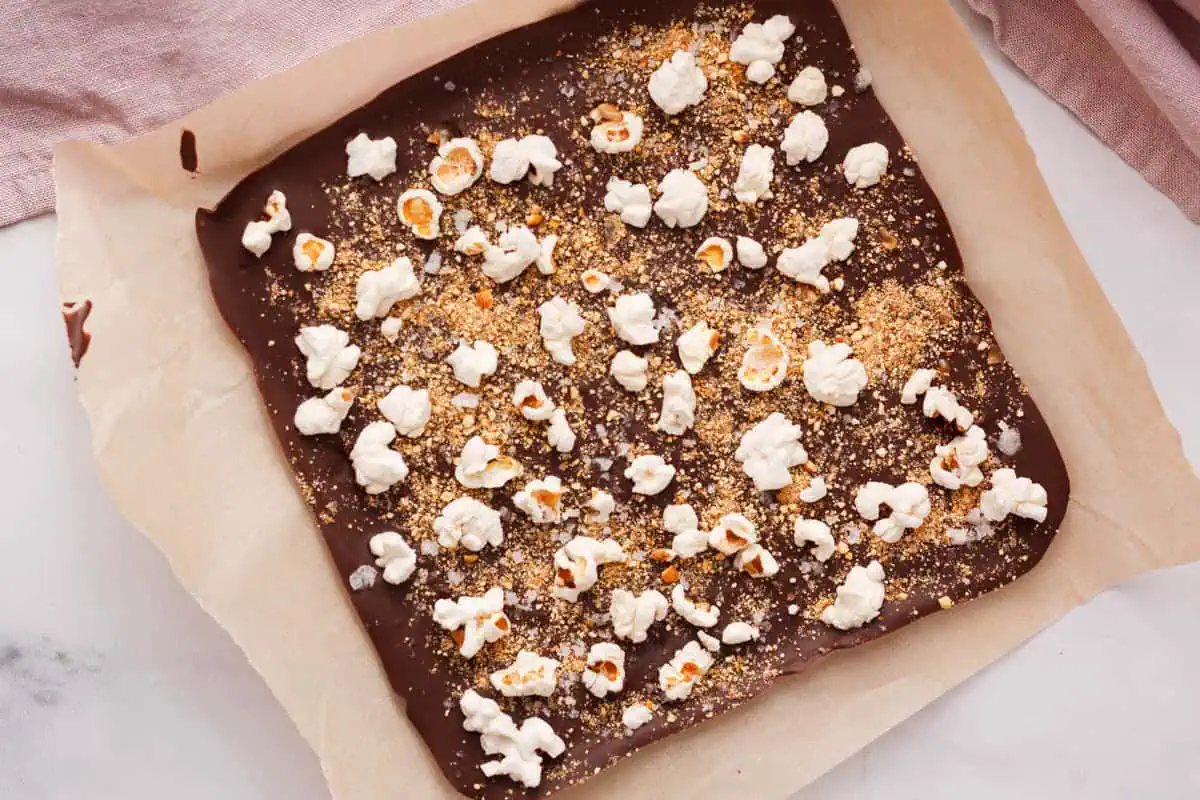 overhead image of popcorn bark on parchment paper after setting in refrigerator
