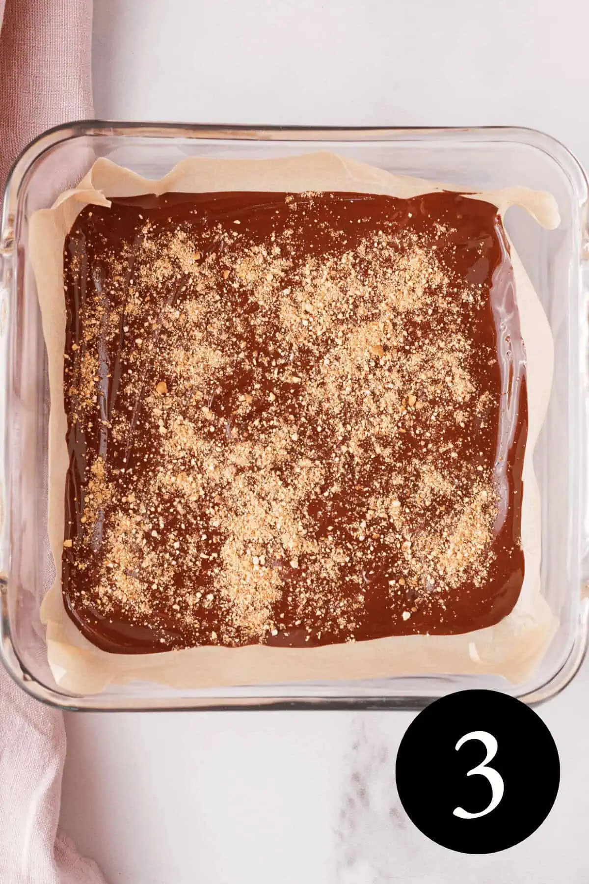 overhead image of melted chocolate in baking dish topped with ground unpopped kernels