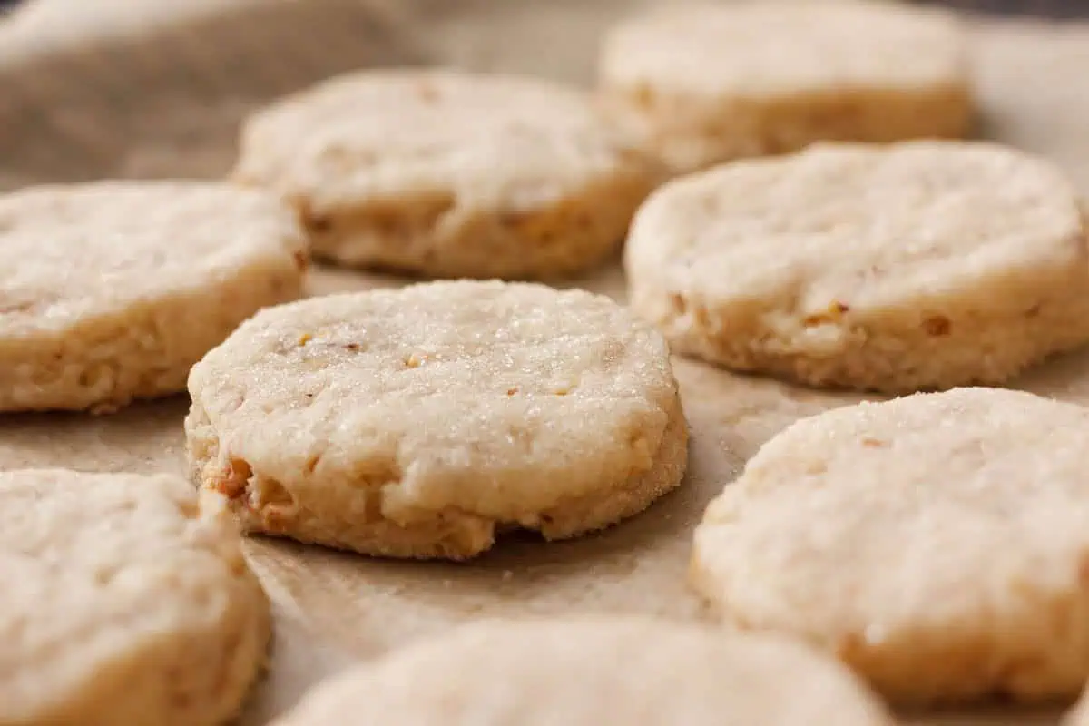 closeup of baked walnut shortbread cookies on parchment paper to show exterior texture