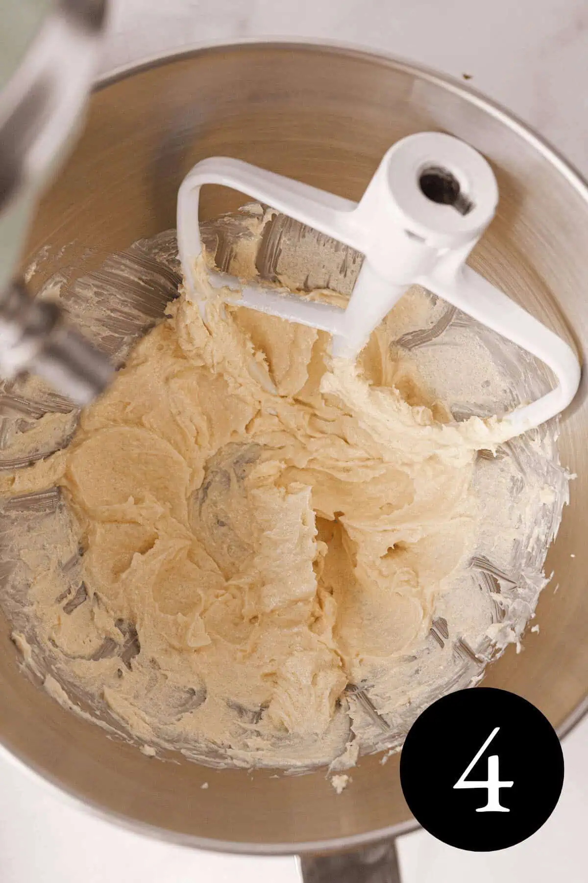 overhead image of butter and other wet ingredients creamed together in stand mixer bowl with attachment resting in the bowl