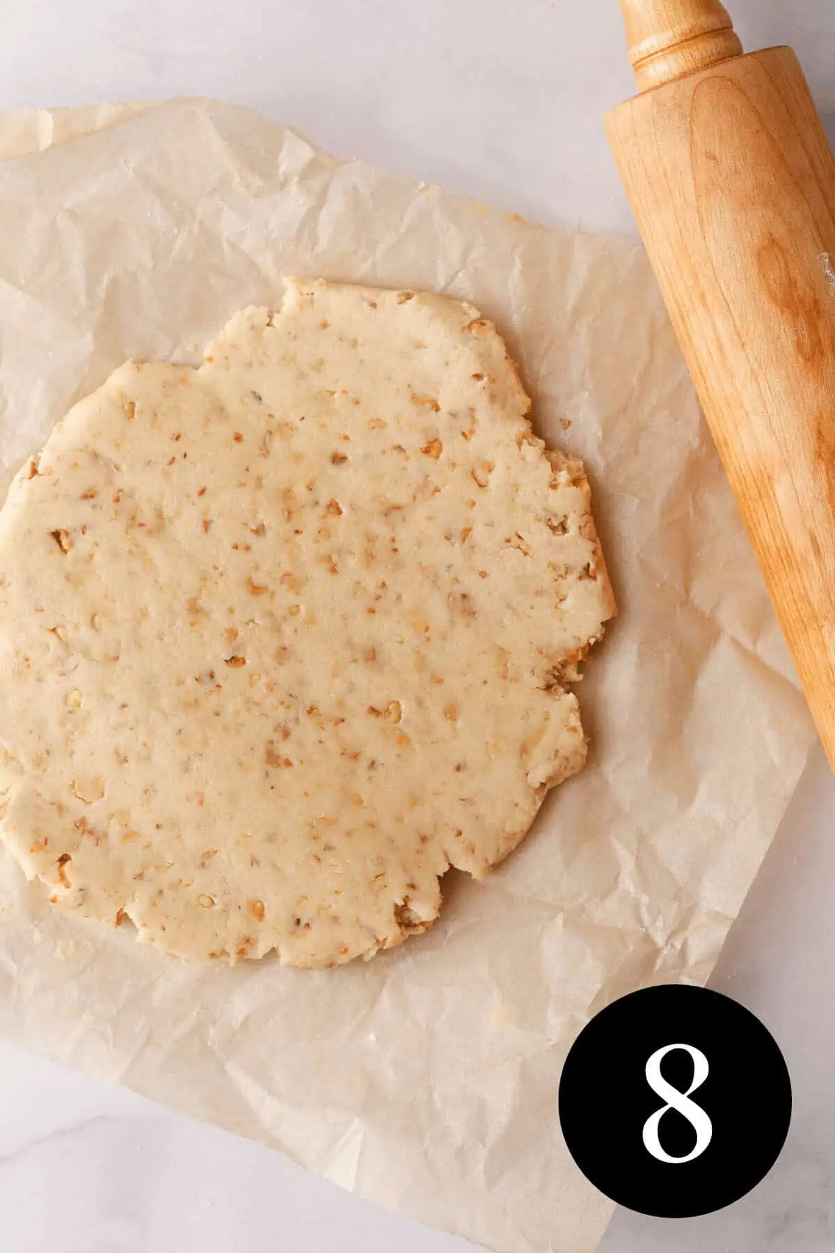 overhead image of shortbread dough rolled into a sheet on parchment paper with rolling pin on the side