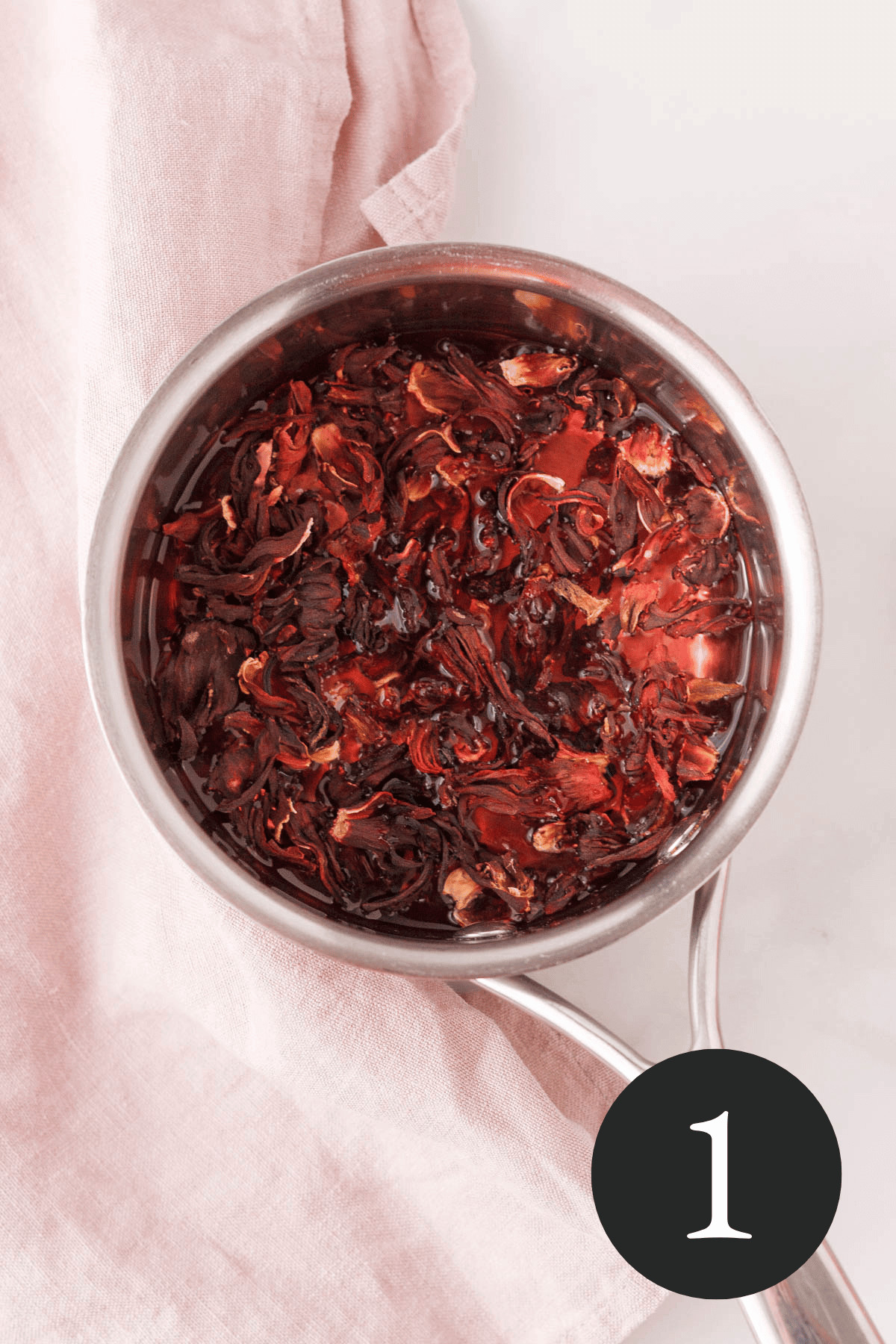 overhead image of dried hibiscus in saucepan with water