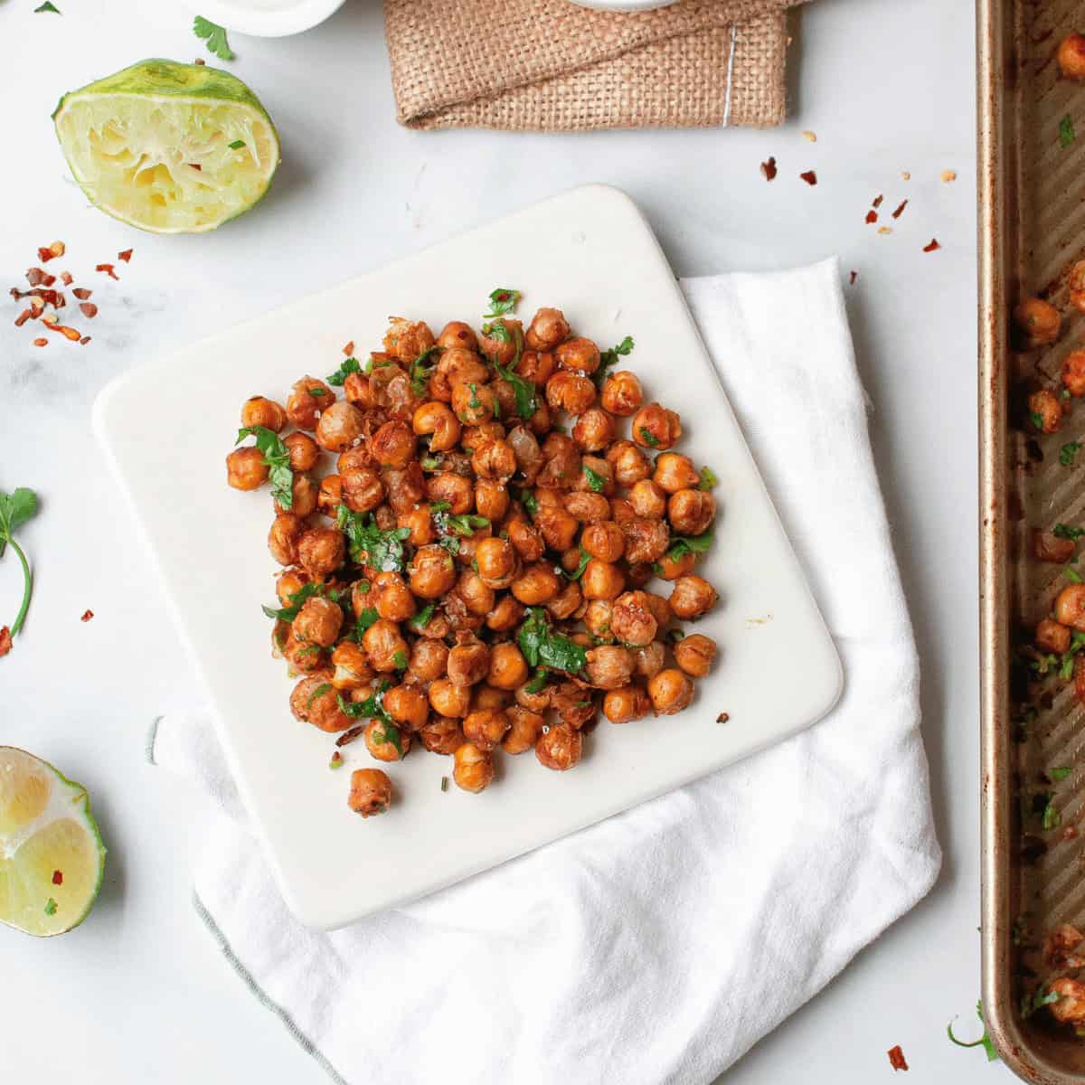 overhead image of roasted chickpeas on white plate with ingredients framing the image