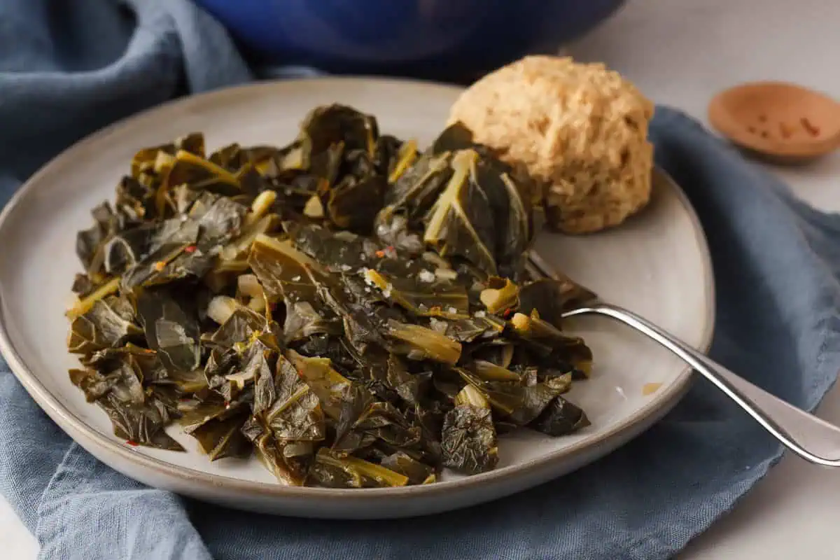 cooked miso collard greens on plate with fork and beer biscuit