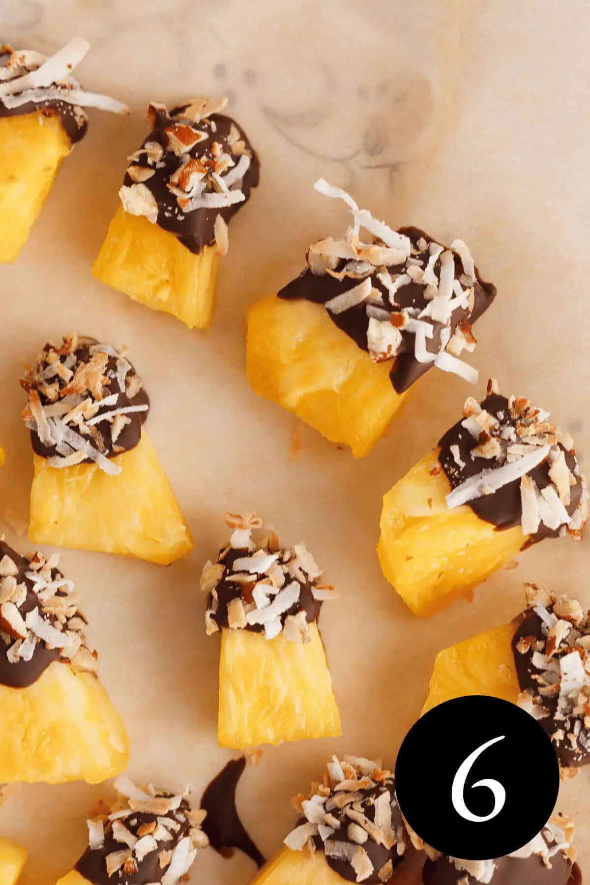 closeup of chocolate covered pineapple pieces on plate with number six in bottom right corner
