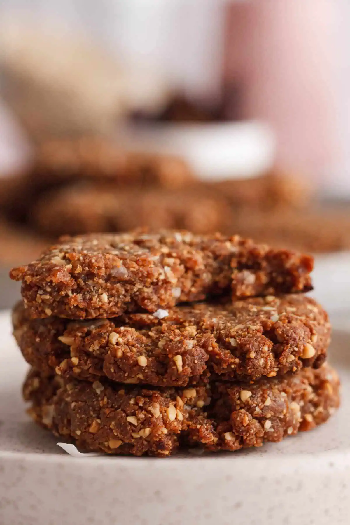 stack of peanut butter date cookies on plate with bite taken out of top cookie