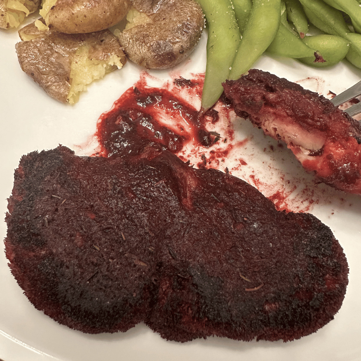 lions mane mushroom steak on plate with edamame and potatoes