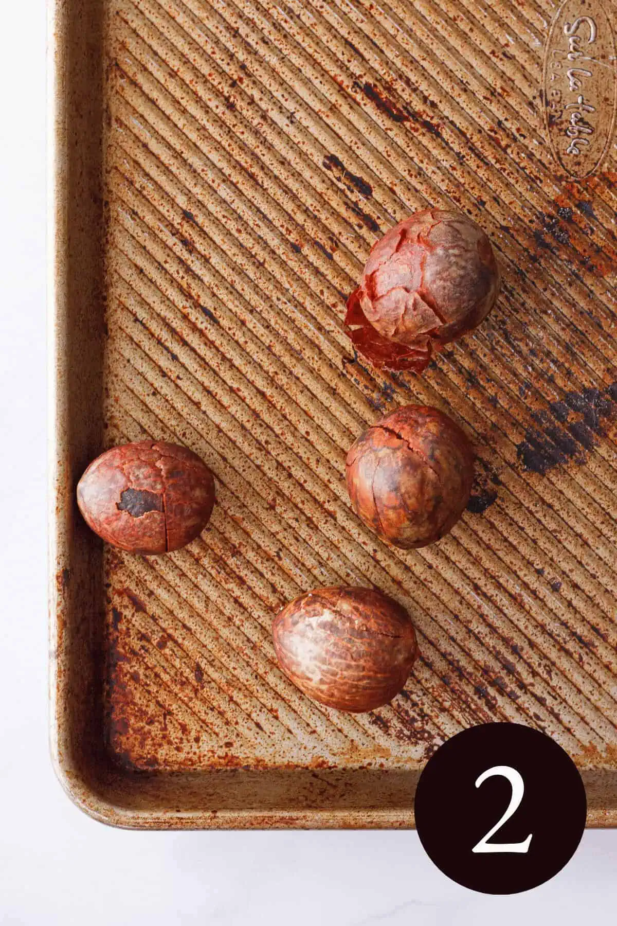 overhead image of dried avocado seeds on baking sheet with number 2 in the bottom right corner