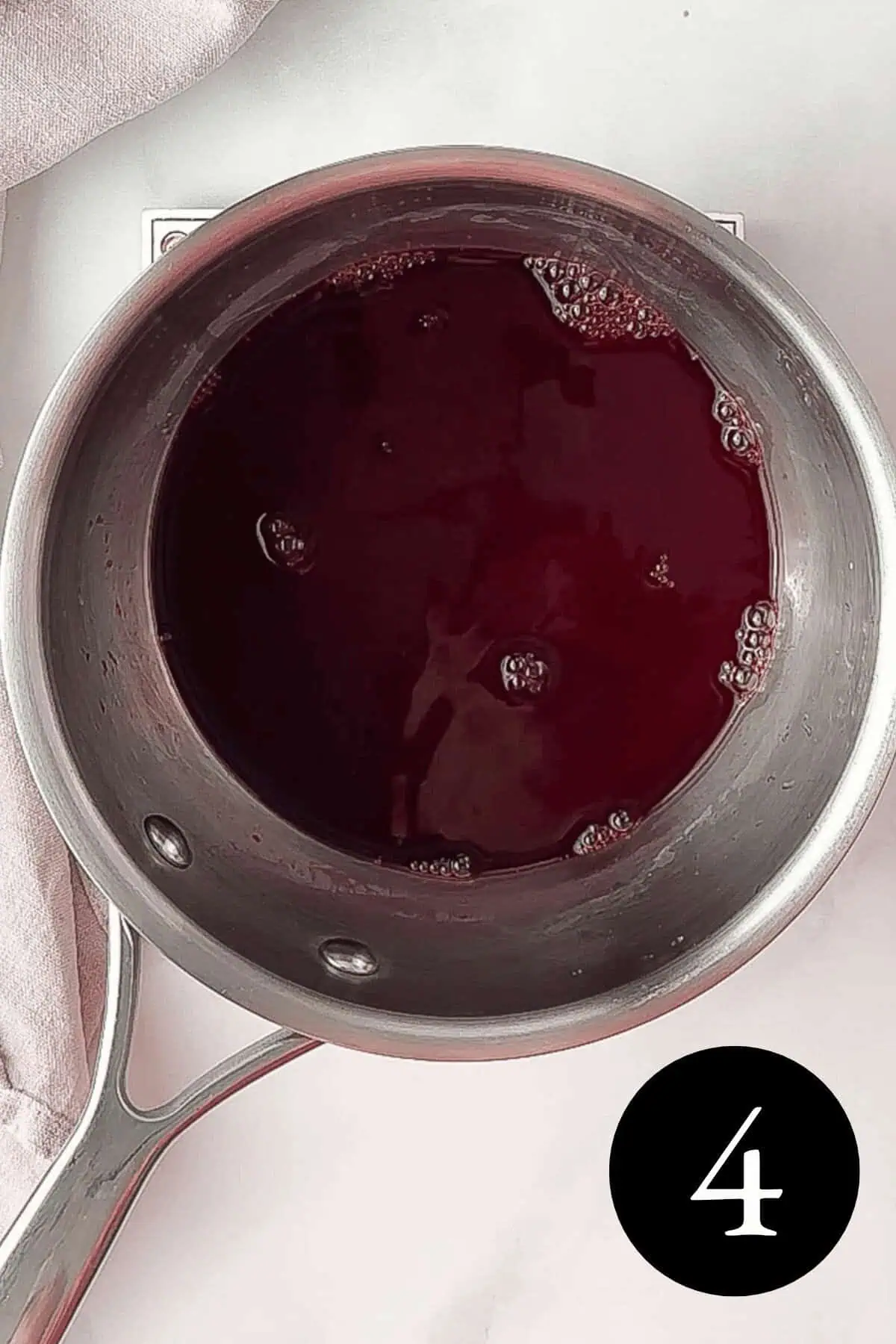 overhead image of blackberry simple syrup in saucepan with number four in bottom right corner